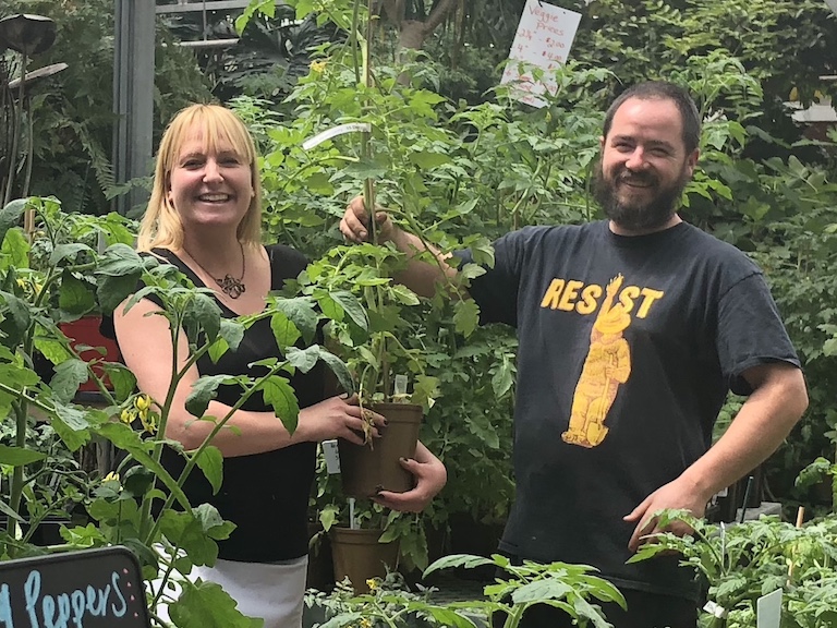 Jenn and Trevor in the greenhouse with tomato plants